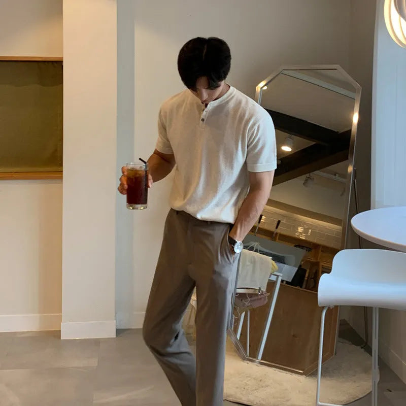 Man wearing a thin black loose-fit knitted short-sleeved pullover shirt.
