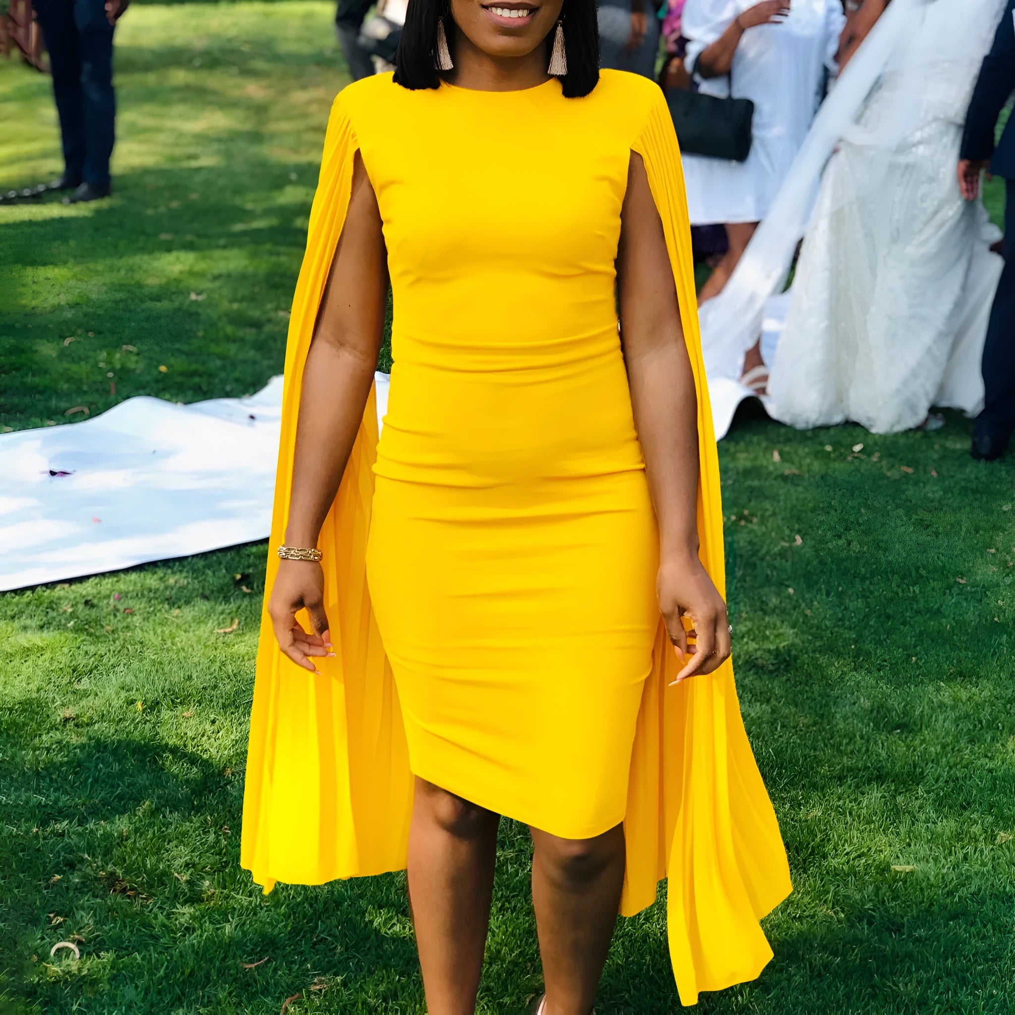 Yellow pleated shawl evening gown with round neckline and long sleeves on mannequin