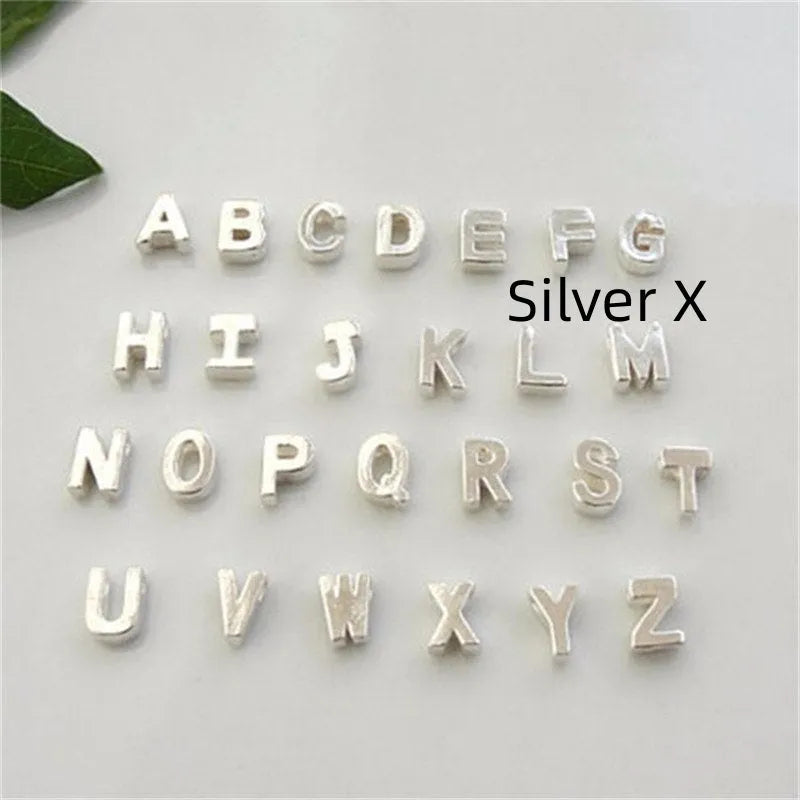 Gold alloy peach heart-shaped pendant with a single letter charm on a silver chain.