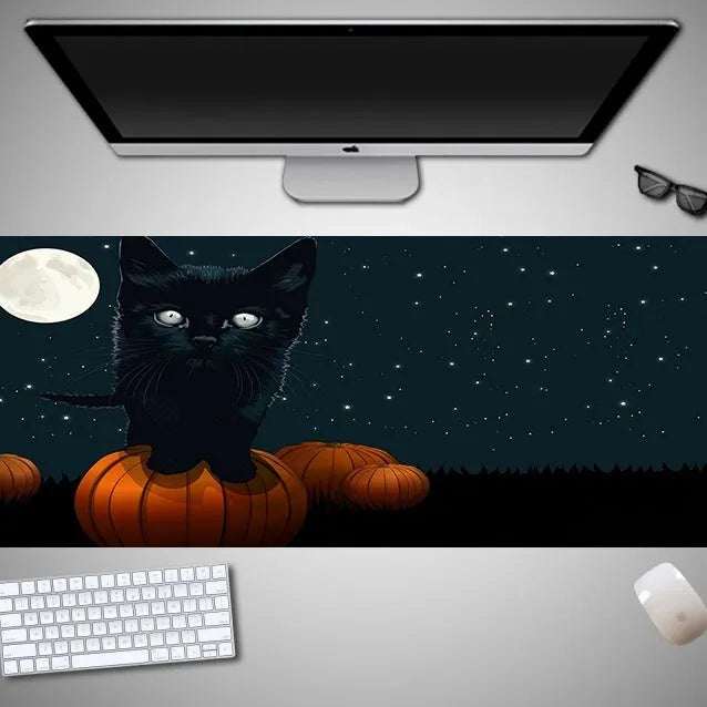 Oversized rectangular Halloween-themed mouse pad on a desk, showing non-slip rubber cloth base.