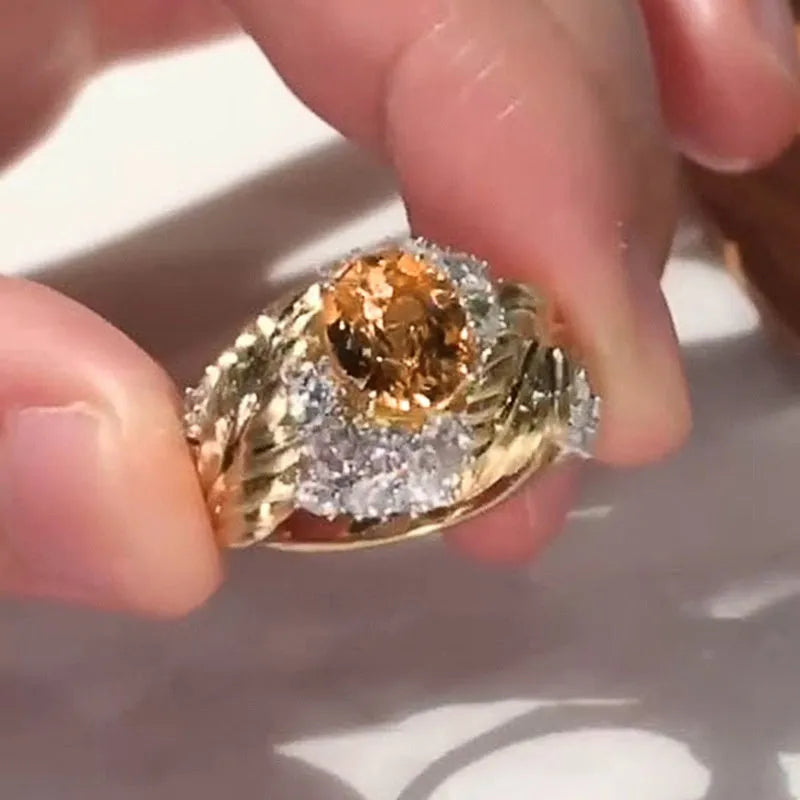 Gold-coloured women's ring with embossed feather pattern and yellow zircon stone inlay on copper base