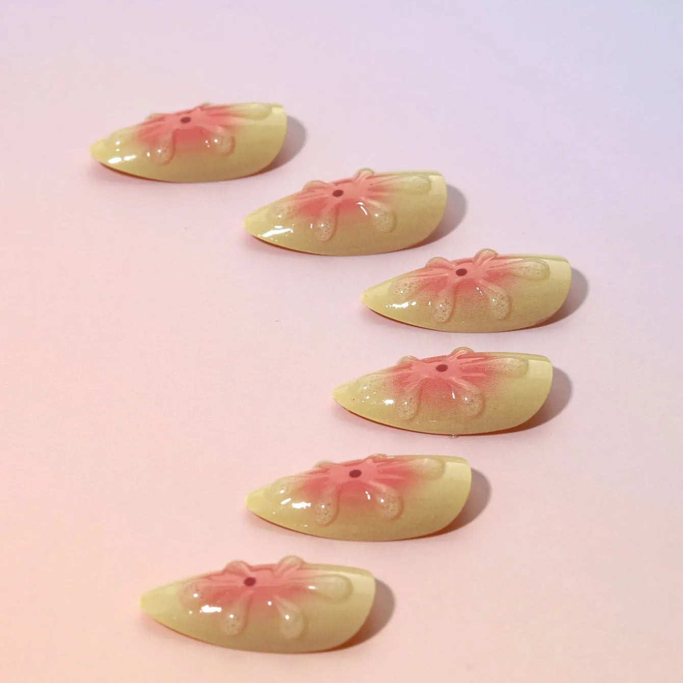 Set of plastic fake nails with 3D raised cartoon flower patterns, jelly glue tube, and a nail filing strip.