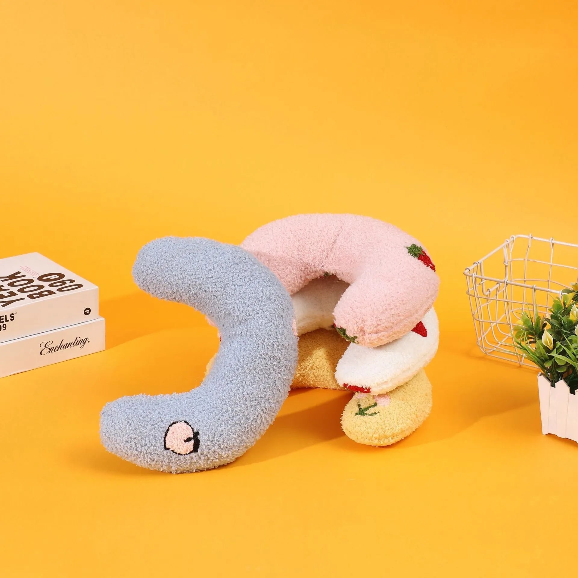 Blue U-shaped half moon cartoon pillow for cats on a wooden floor.