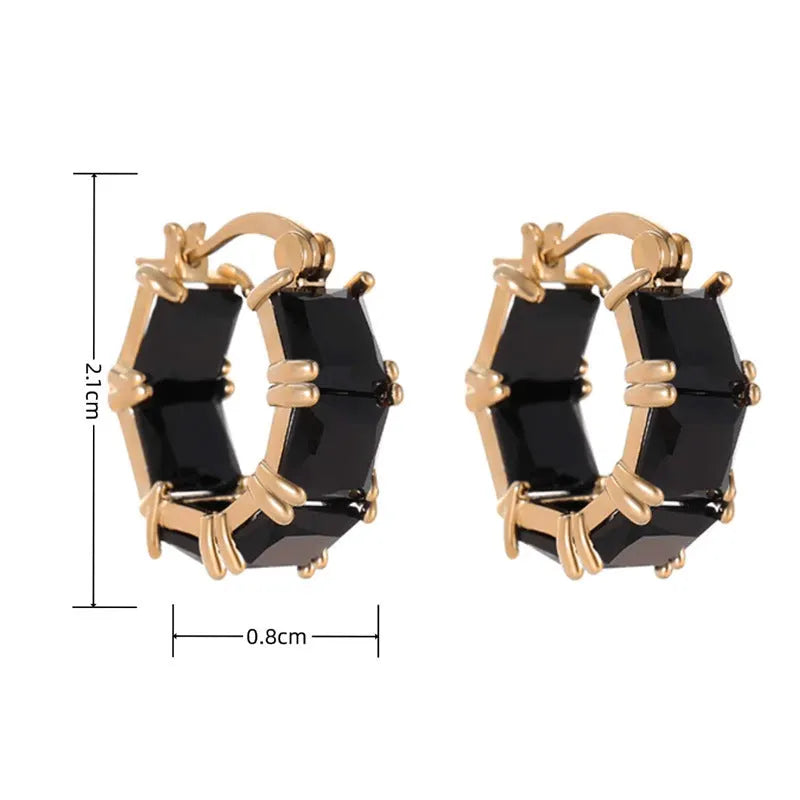 Geometric U-shaped gold earring with a round black zirconium stone on a copper base.