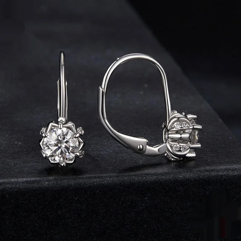 Sterling silver flower bud shaped ear clips with a white gold plated finish and a central moissanite stone.