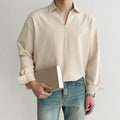 Man wearing a loose fit lapel collar casual shirt in a solid colour.