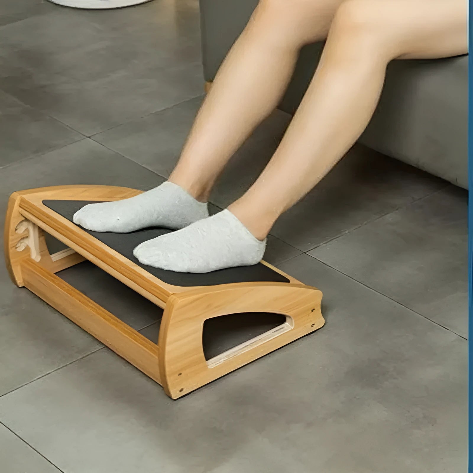 Wooden adjustable bamboo office desk footstool in natural wood colour, shown as an under-desk ergonomic foot rest.