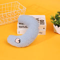 Blue U-shaped half moon cartoon pillow for cats on a wooden floor.