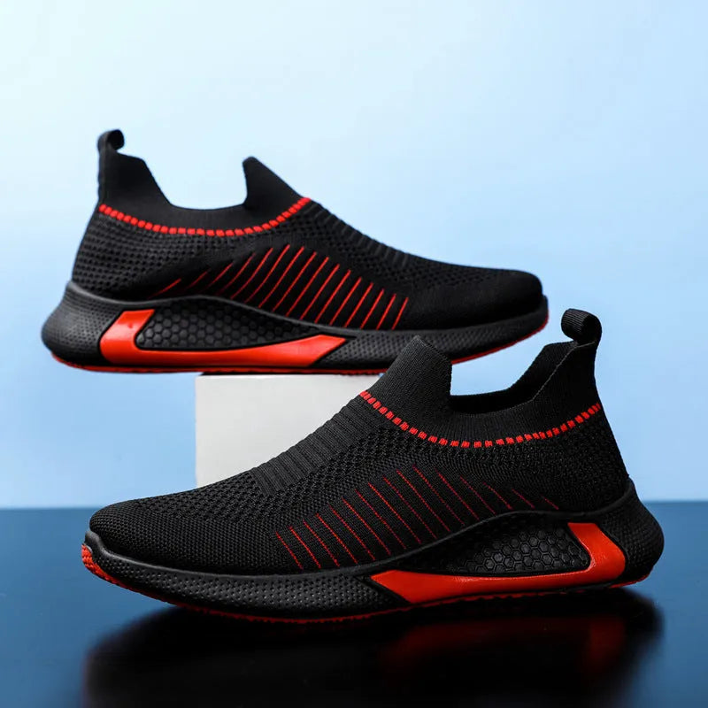 Men's black and white mesh slip-on sneakers with striped design and flat sole.