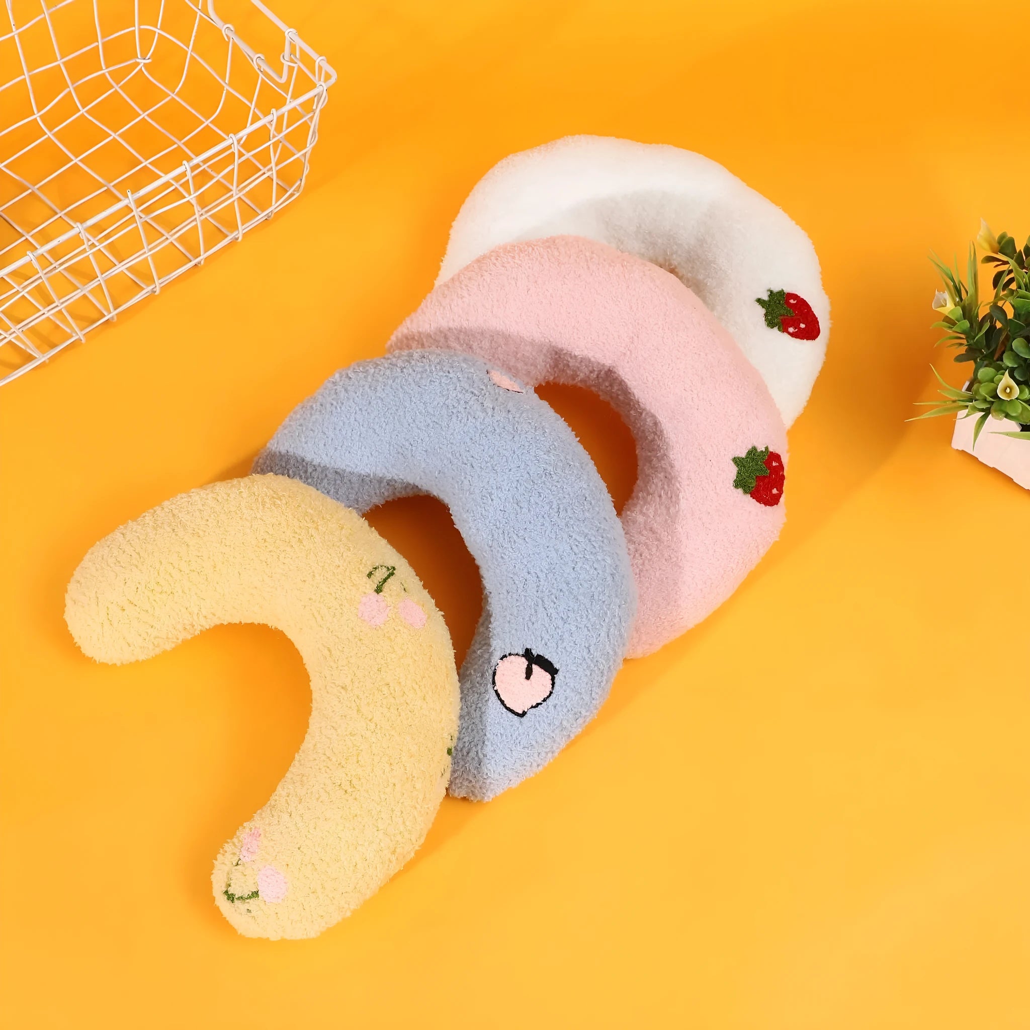Blue U-shaped half moon cartoon pillow for cats on a wooden floor.