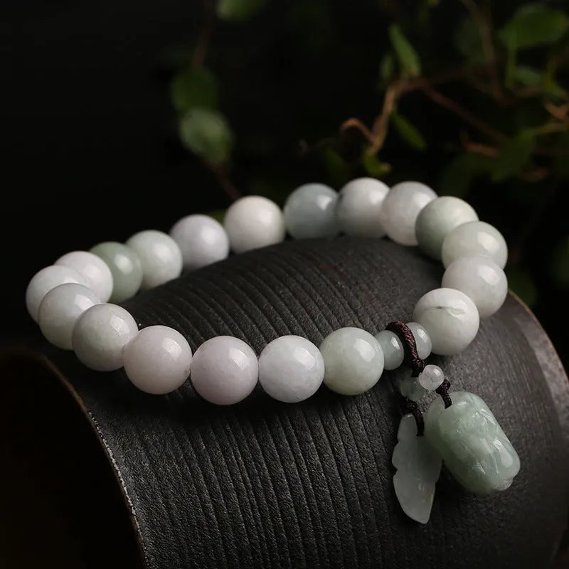 Natural green jade bracelet with Maitreya Buddha charm pendant on a wrist.