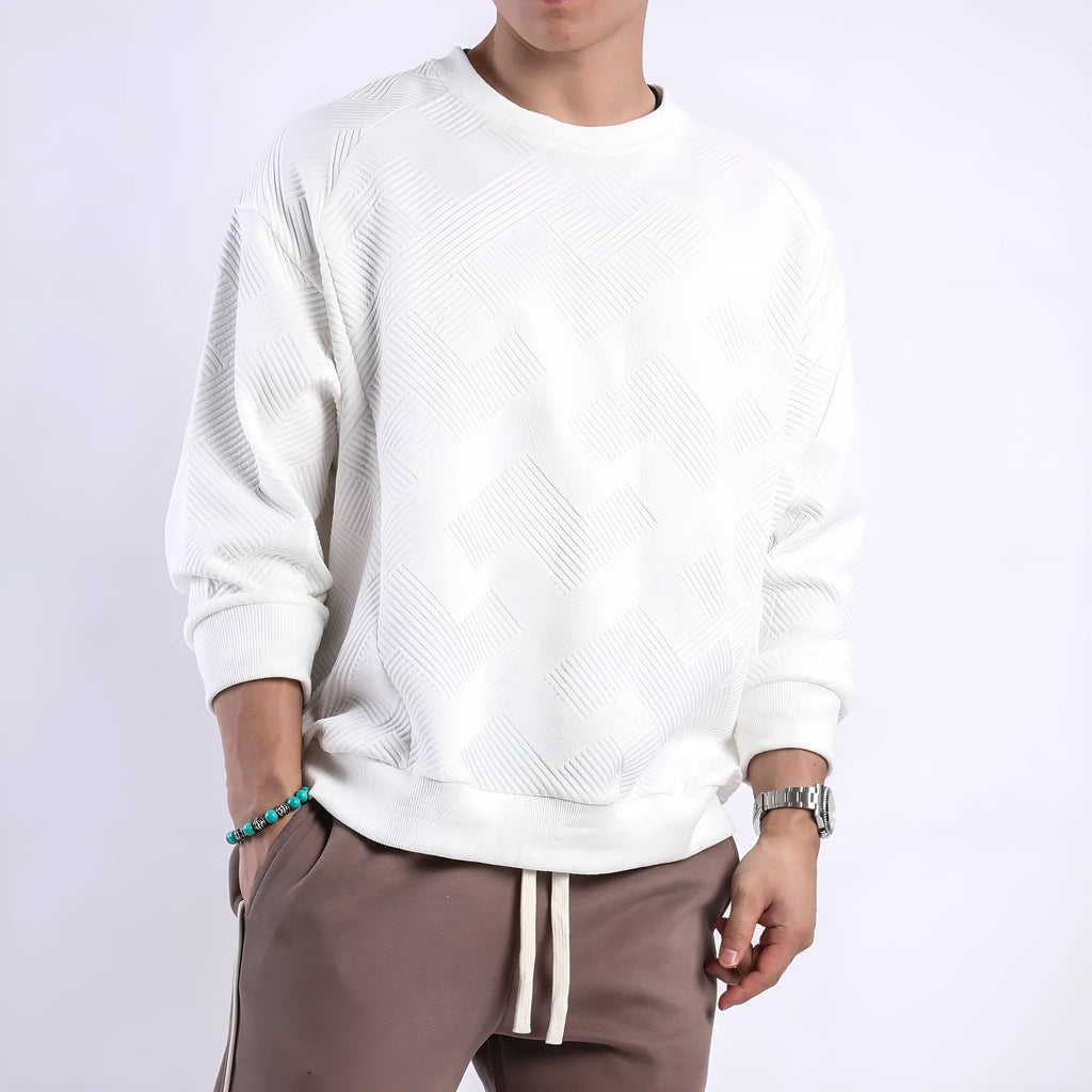 Man wearing a loose-fit, solid-colour twill jacquard long-sleeved sweater with a round neck.