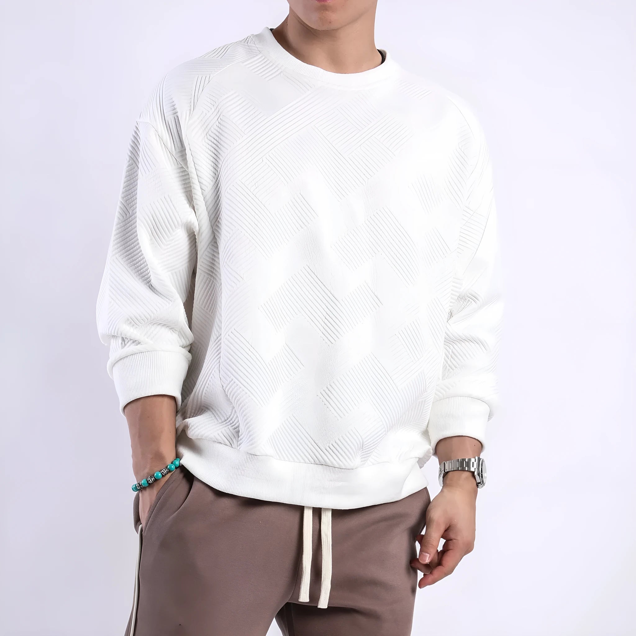 Man wearing a loose-fit, solid-colour twill jacquard long-sleeved sweater with a round neck.