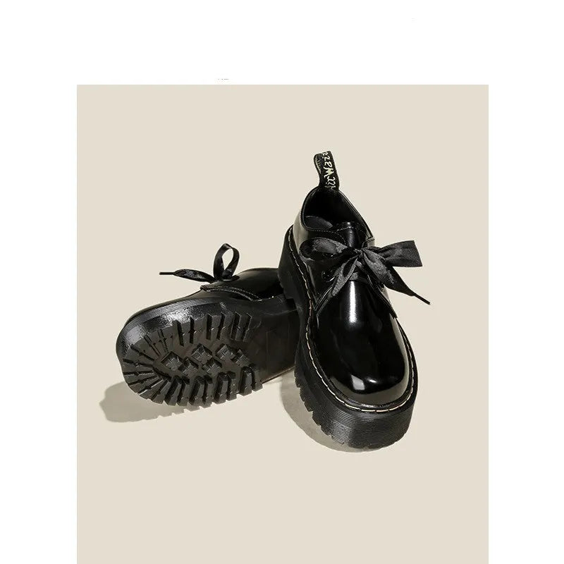 Women's thick soled leather shoes with ribbon cross straps and lace-up closure in black colour