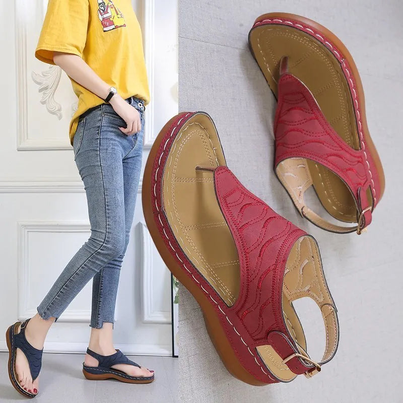 Women's wedge heel flip flop sandals with an adjustable back buckle strap in black.