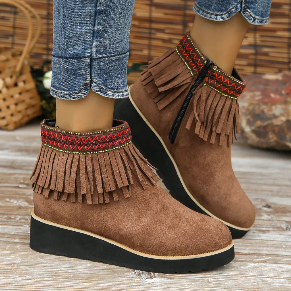 Women's black suede wedge ankle boots with a side zip and tassel detail on a thick rubber sole.