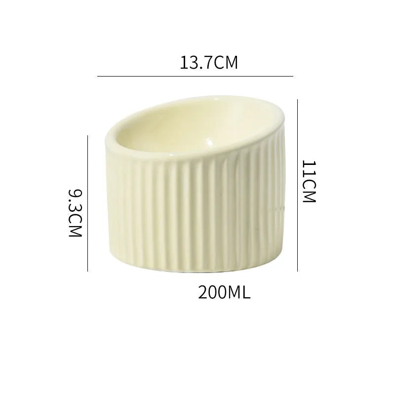 Ceramic elevated cat bowl in green or yellow with a tilted, round, whisker-friendly design.