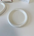 White ceramic plate with black hand-drawn doodle design, shown in bear and round patterns.