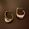 Metal twisted geometric hoop earrings with electroplated gold or silver finish showing round wire design