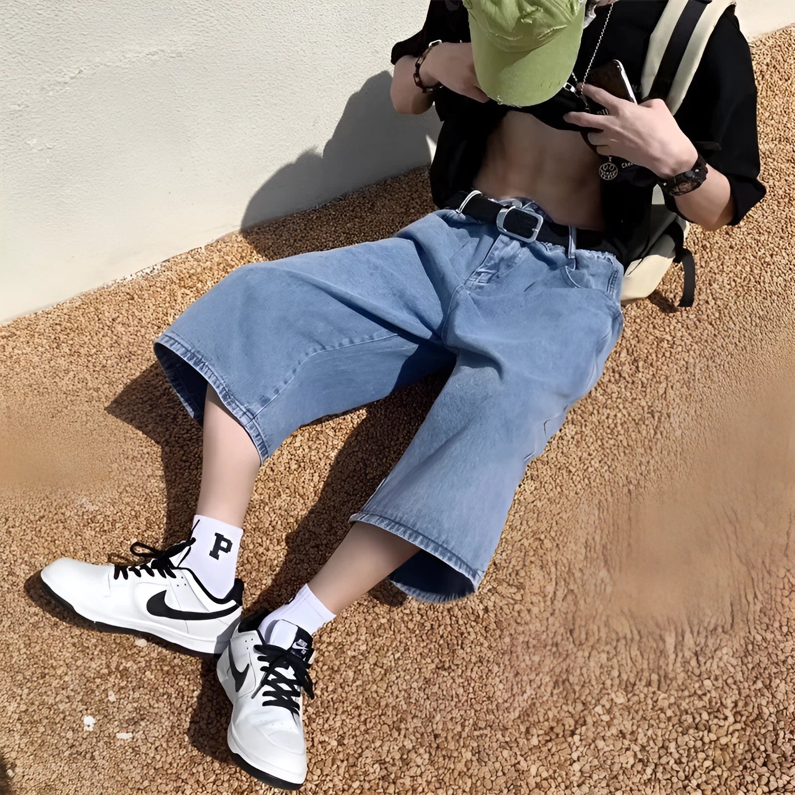 Men's washed light blue denim cropped shorts with a high waist and zipper fly.