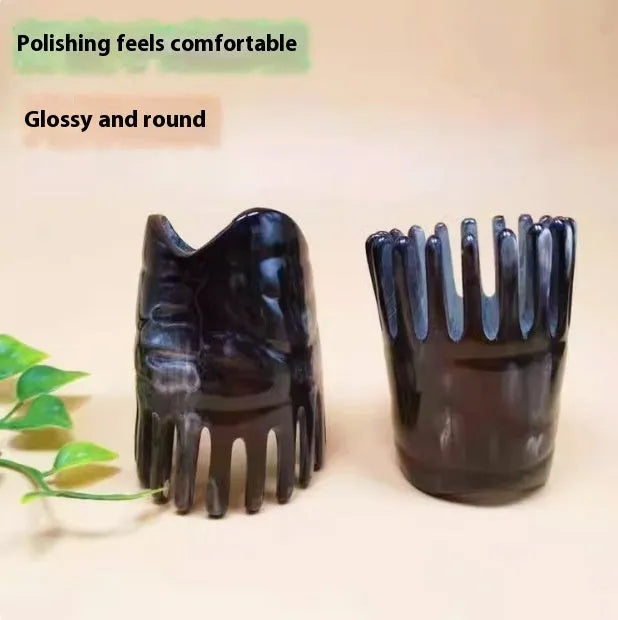 A black horn comb with wide teeth on one side and a pointed tip for scalp massage.