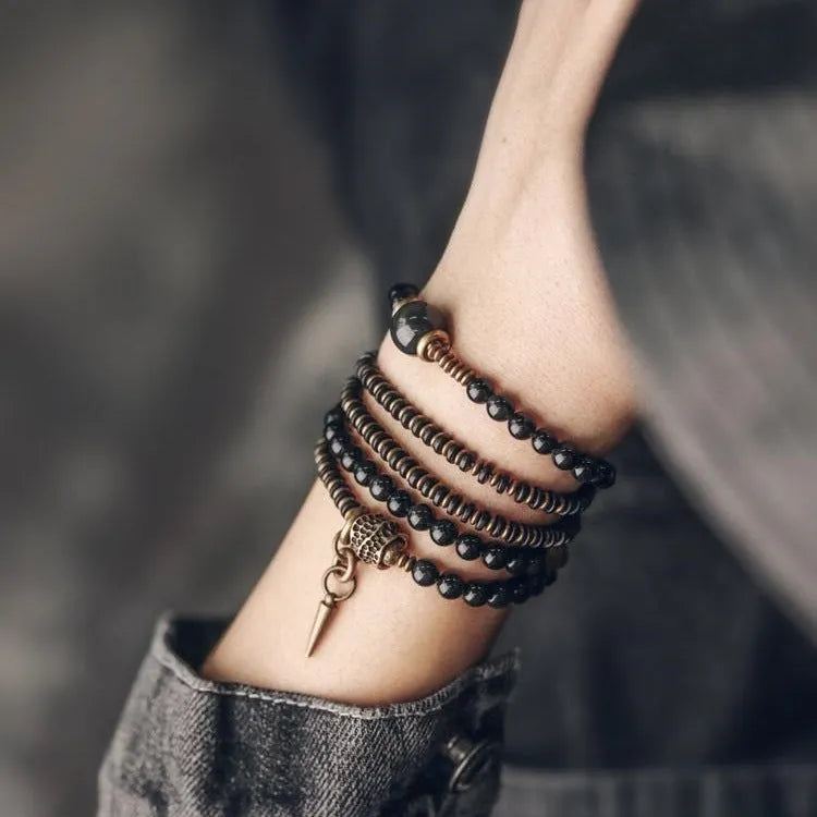 Close-up of a black multi-layered geometric bracelet made from beads, showing its textured construction.