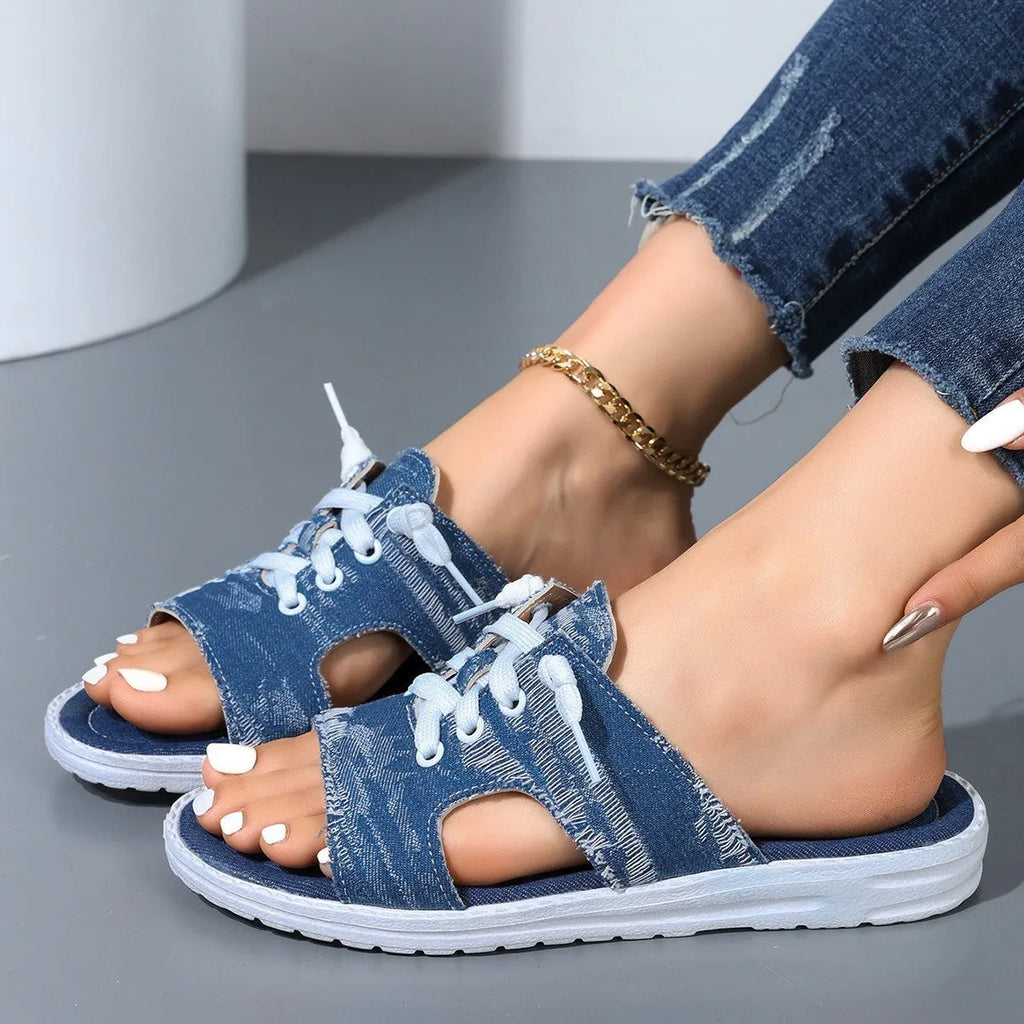 Blue Roman-style women's flat canvas slippers with cloth upper and rubber sole.