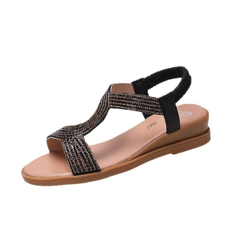 Gold women's patent leather beach sandals with rhinestones on the strap and a round toe.