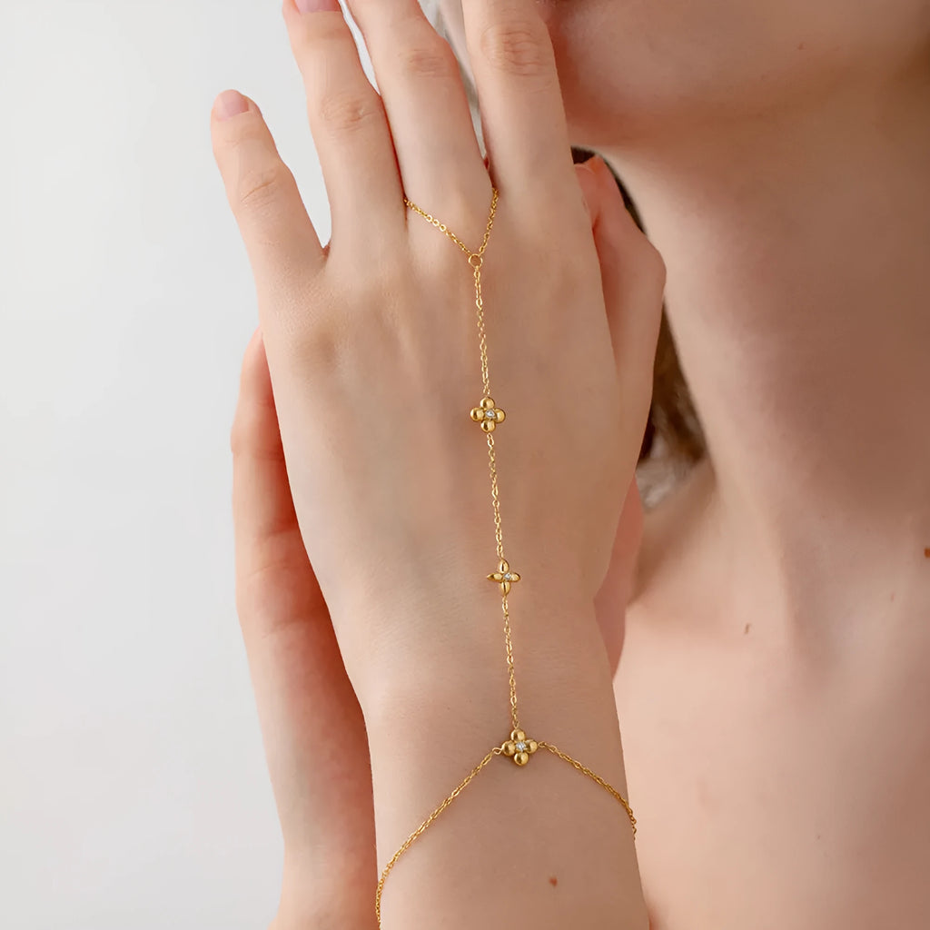 Gold-coloured stainless steel women's bracelet with eight-pointed star shape and floral decorative elements
