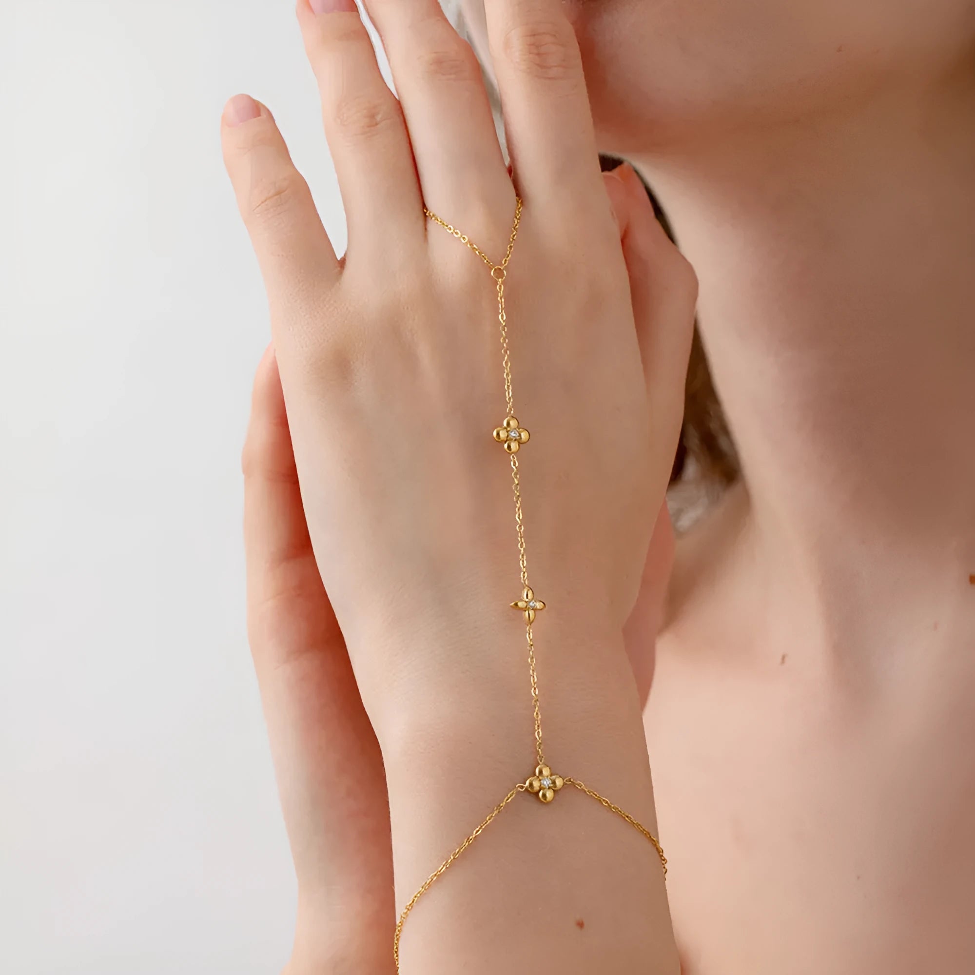 Gold-coloured stainless steel women's bracelet with eight-pointed star shape and floral decorative elements