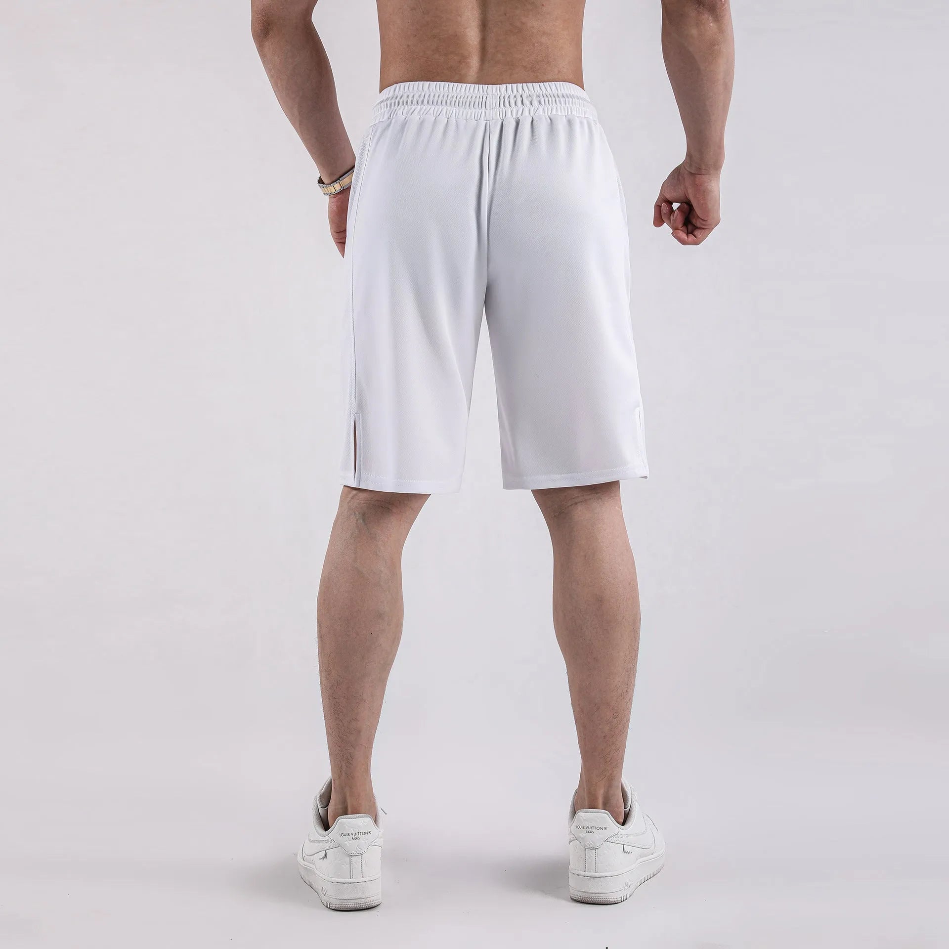 Man wearing loose-fitting black quick-dry mesh shorts with an elasticated waist.