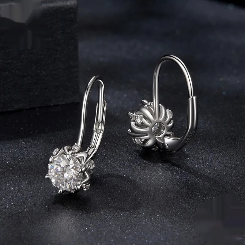 Sterling silver flower bud shaped ear clips with a white gold plated finish and a central moissanite stone.