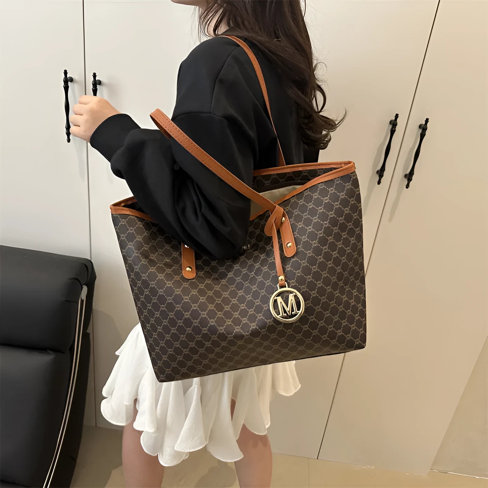 Structured black PU leather shoulder bag with adjustable strap and visible sewing thread detailing