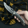 Damascus steel folding knife with carbon fibre handle and 9cm VG10 blade open on wood surface