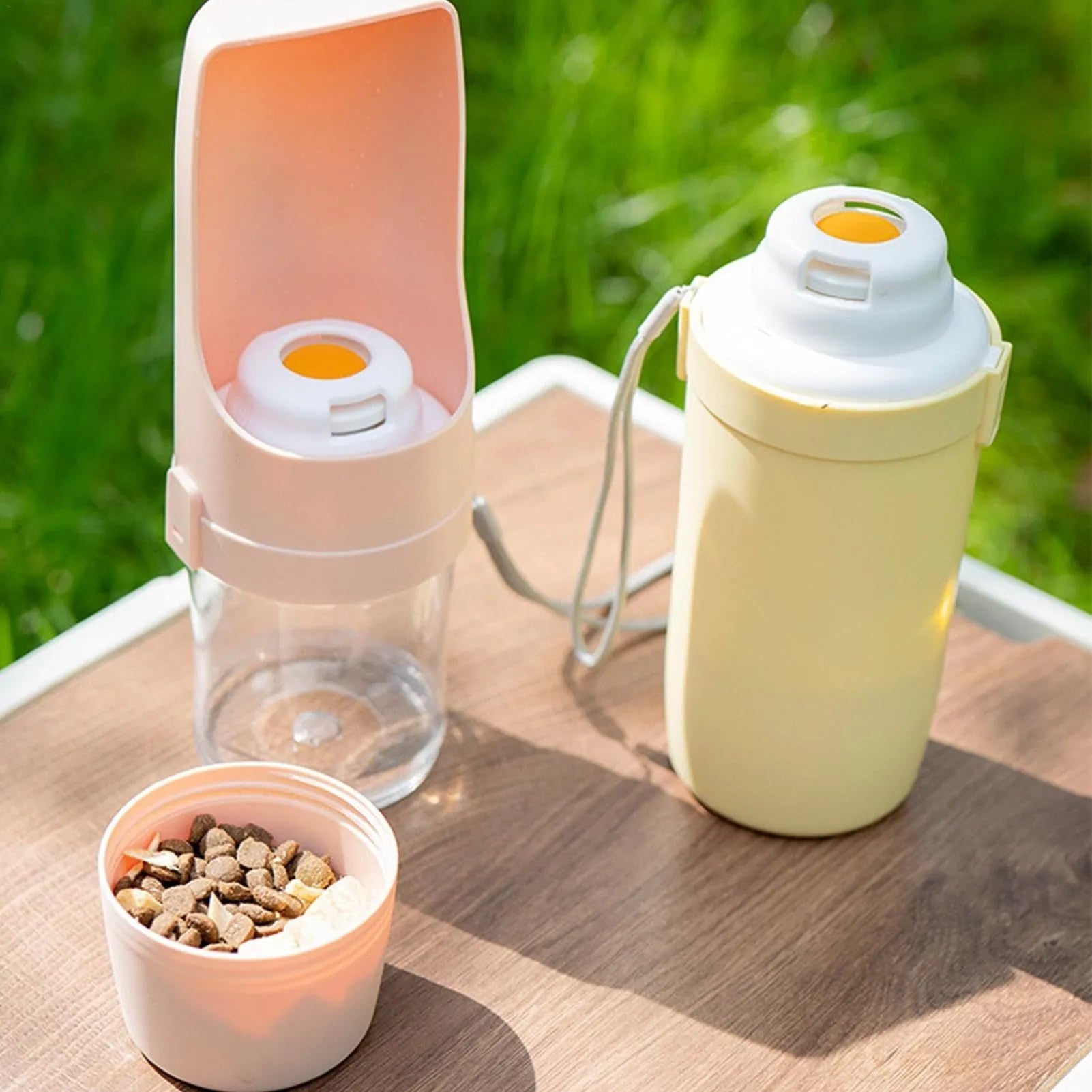 Gray 2-in-1 travel dog water bottle and feeder with lanyard, showing folding design and drinking cup.