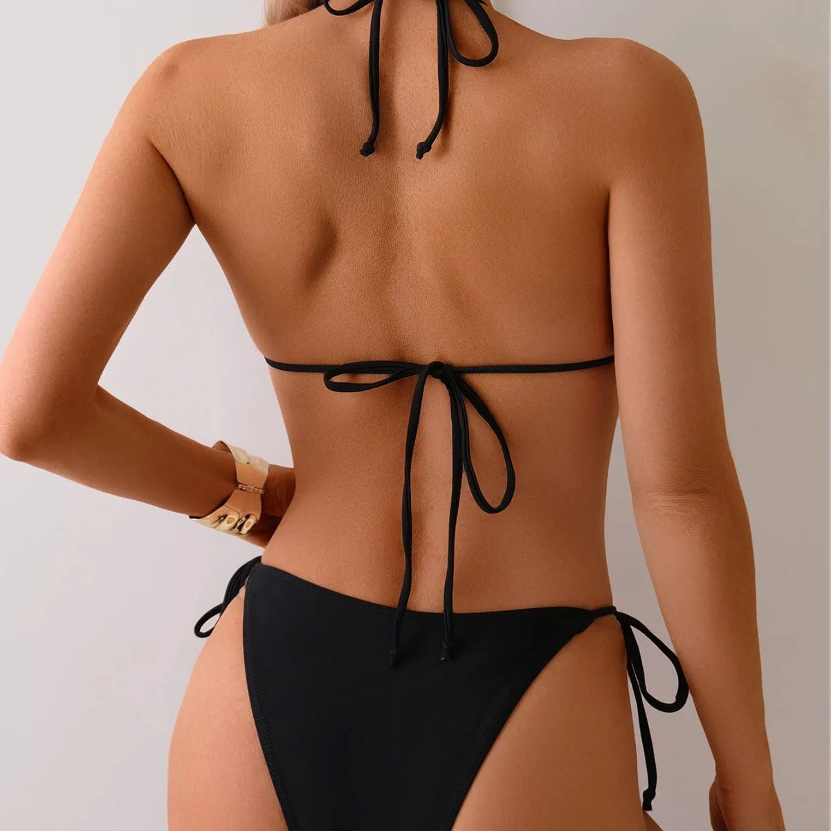 Black women's bikini swimsuit with metal bead decoration and split leg design