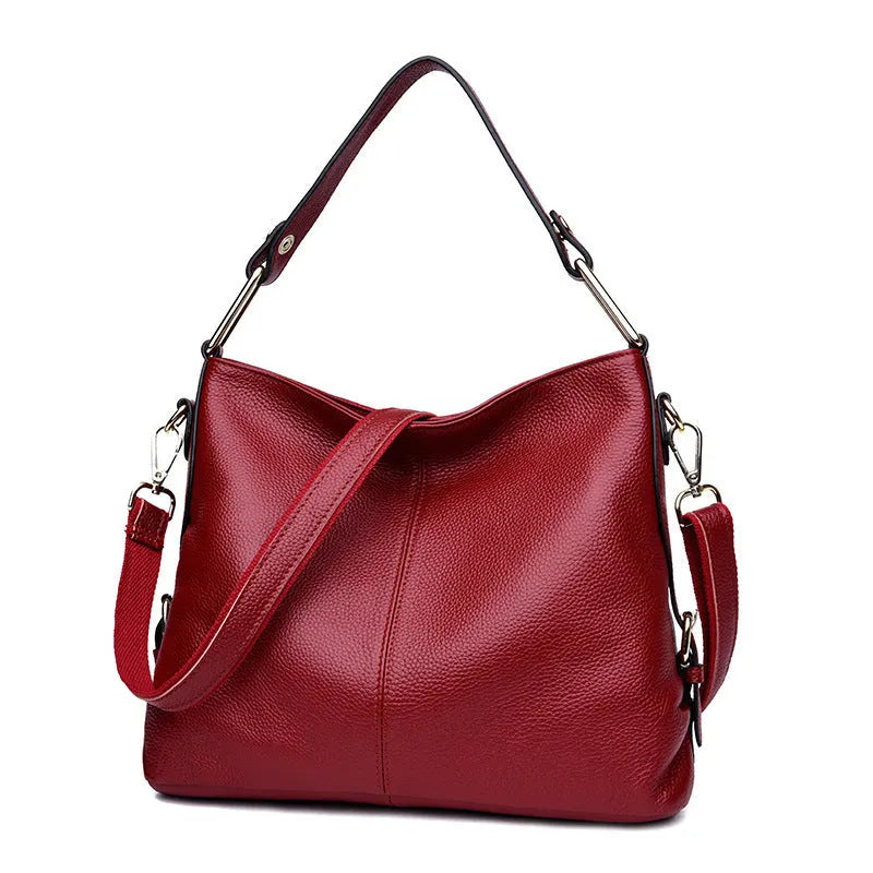 Genuine leather vertical square crossbody bag in black, showing front sandwich pocket and sewing line details.