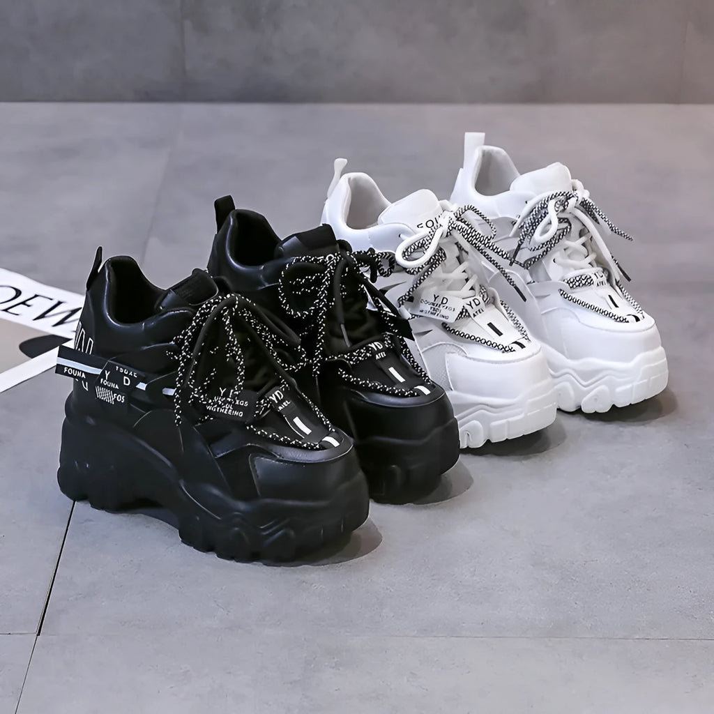 Women's white low-top platform tennis shoes with mesh upper and cross-strap detail on a rubber sole.