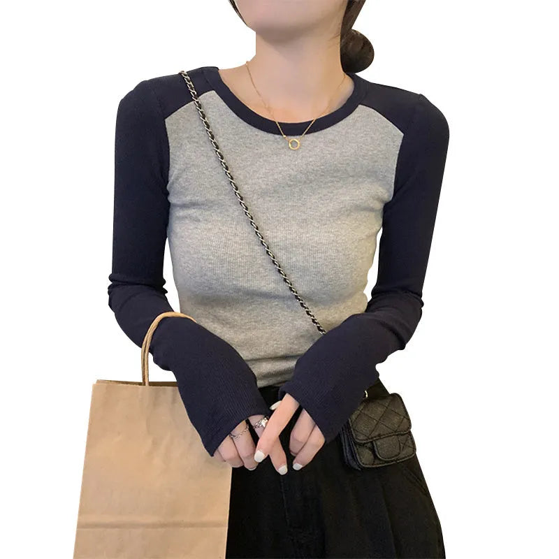 Women's black viscose top with long princess sleeves and embroidery detail on a hanger.