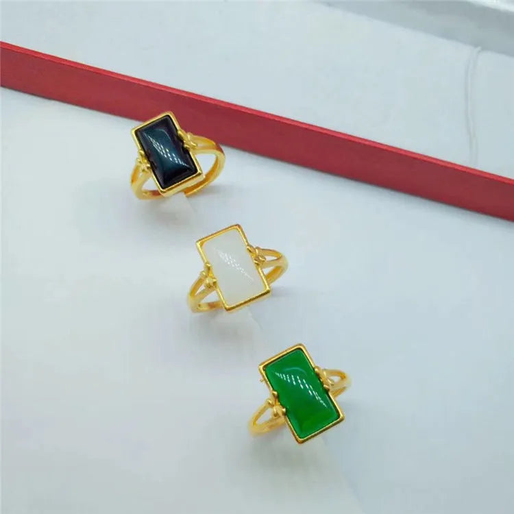 Adjustable gold-plated brass ring with a central gemstone inlay on a model's finger.