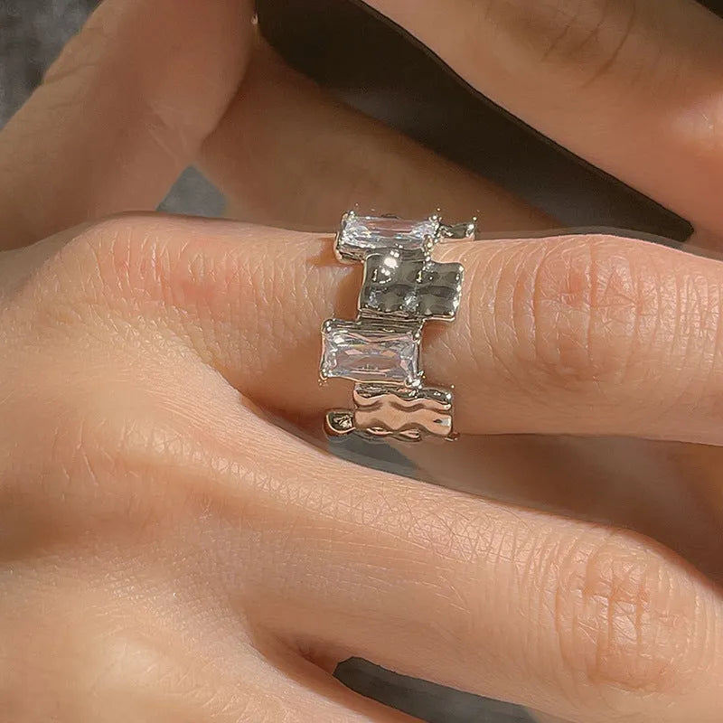 Geometric cross zircon ring with silver plating and open gemstone setting showing three-dimensional decoration
