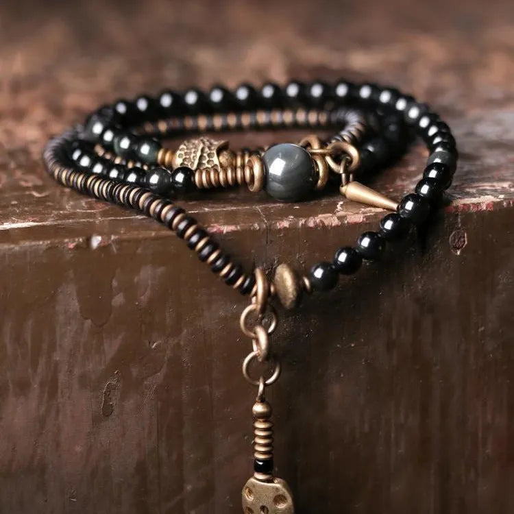 Close-up of a black multi-layered geometric bracelet made from beads, showing its textured construction.