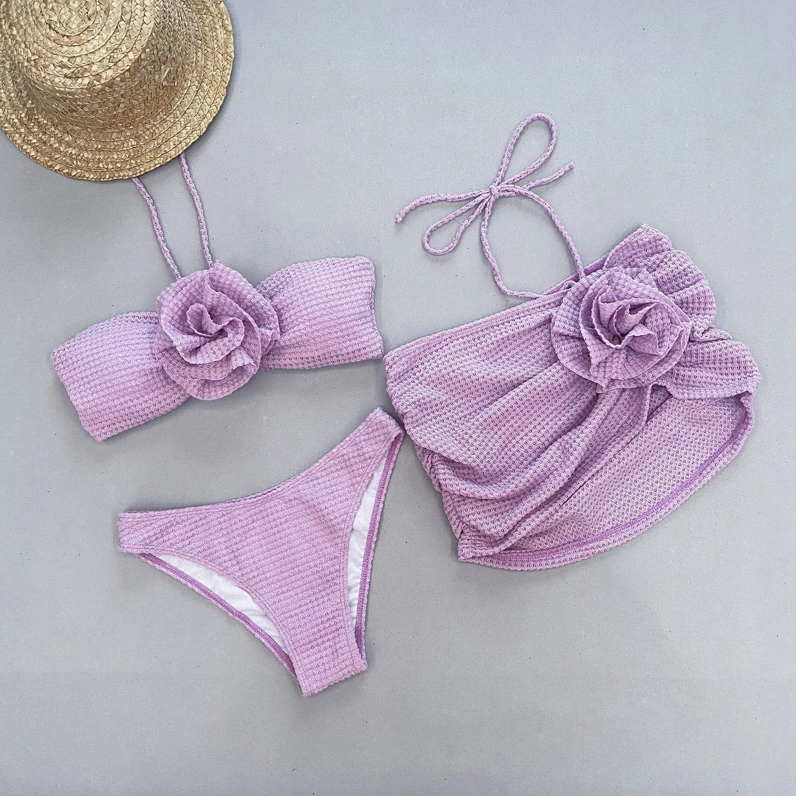 Women's white three-piece bikini set with 3D flower split design on a solid background.