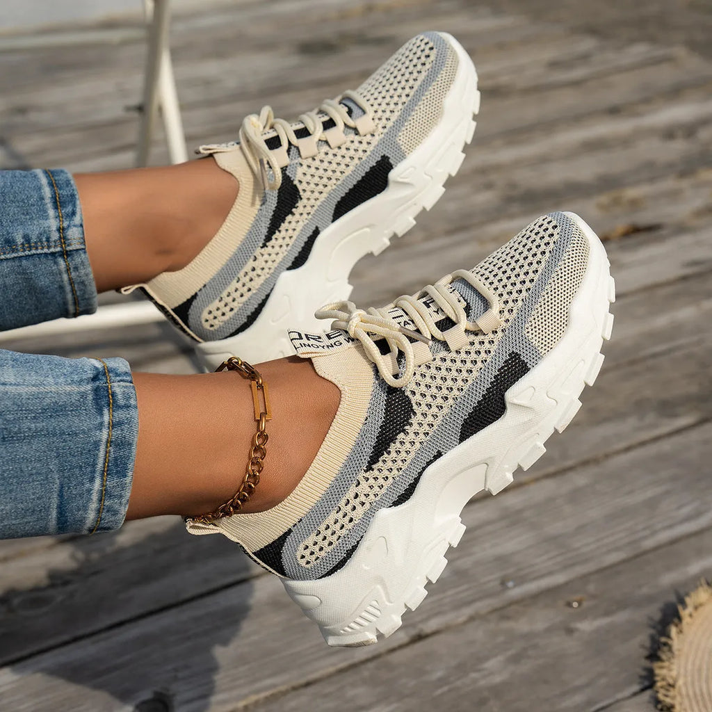 Women's low heel Flyknit mesh sneakers in a grey colour scheme with lace-up front.