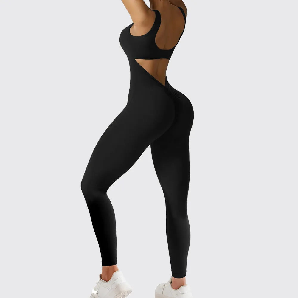 Woman wearing a sleeveless army green flare jumpsuit for yoga or fitness.