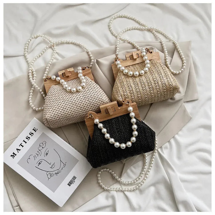 Women's woven straw shoulder bag with pearl chain strap in beige, showing its horizontal square shape.