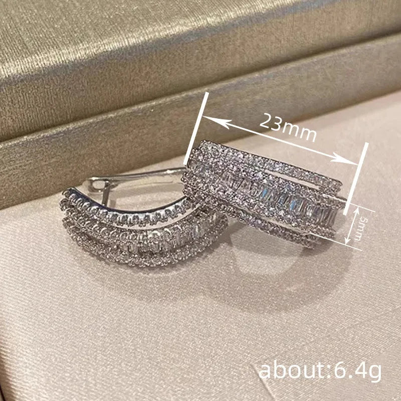 A pair of geometric shaped stud earrings with inlaid zircon stones in a white gold colour finish.
