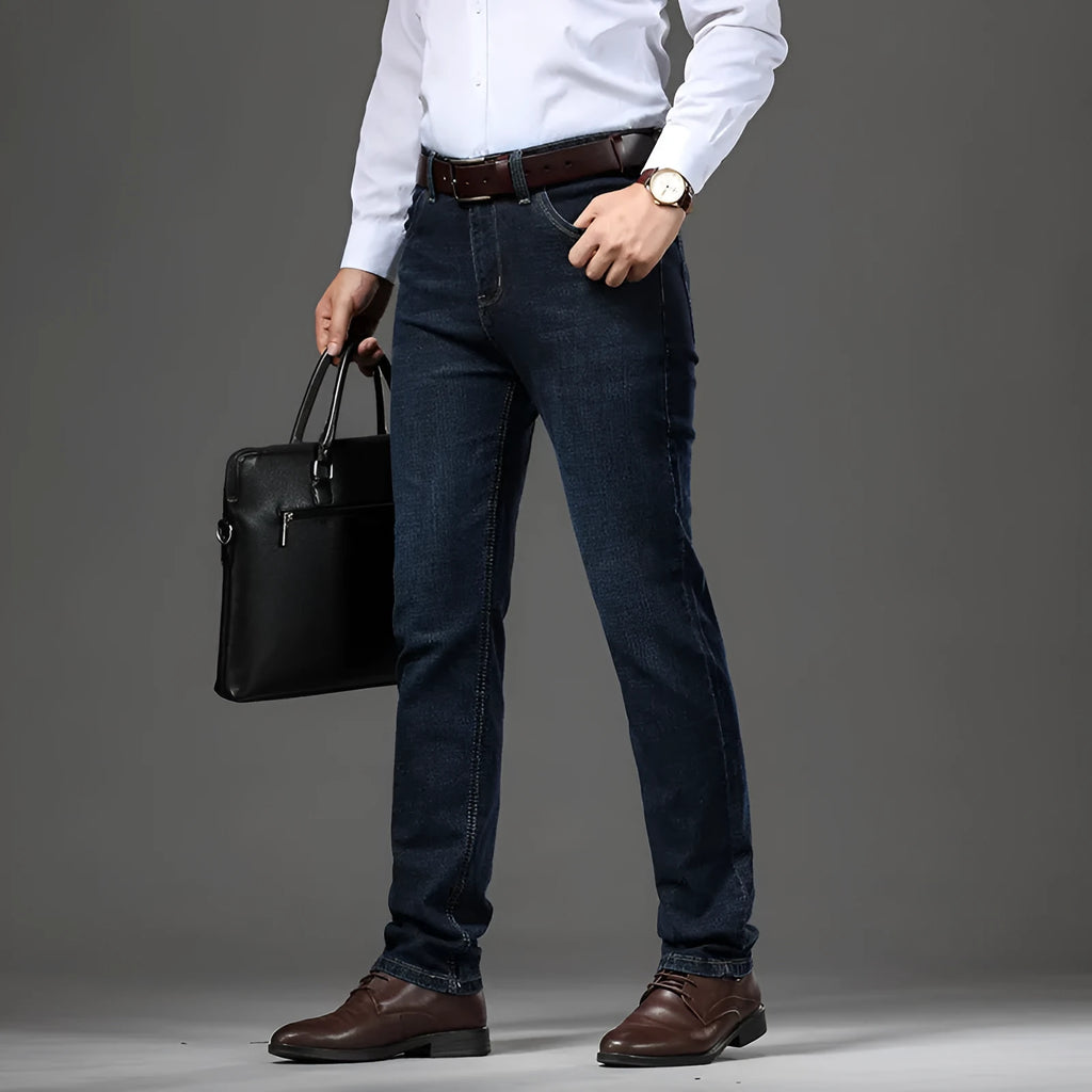 Man wearing straight-leg black stretch denim jeans with a mid waist and zip fly.