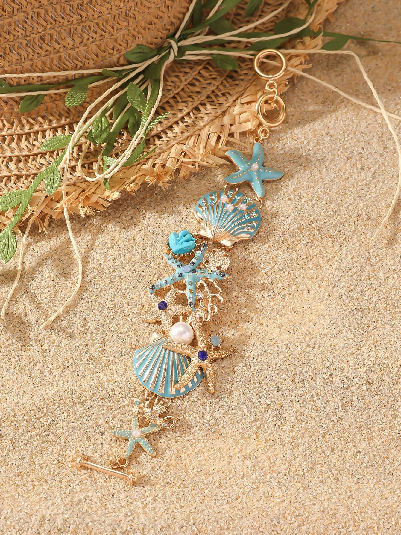 Starfish-shaped alloy bracelet with rhinestone anchor and shell details in turquoise, red, or blue.