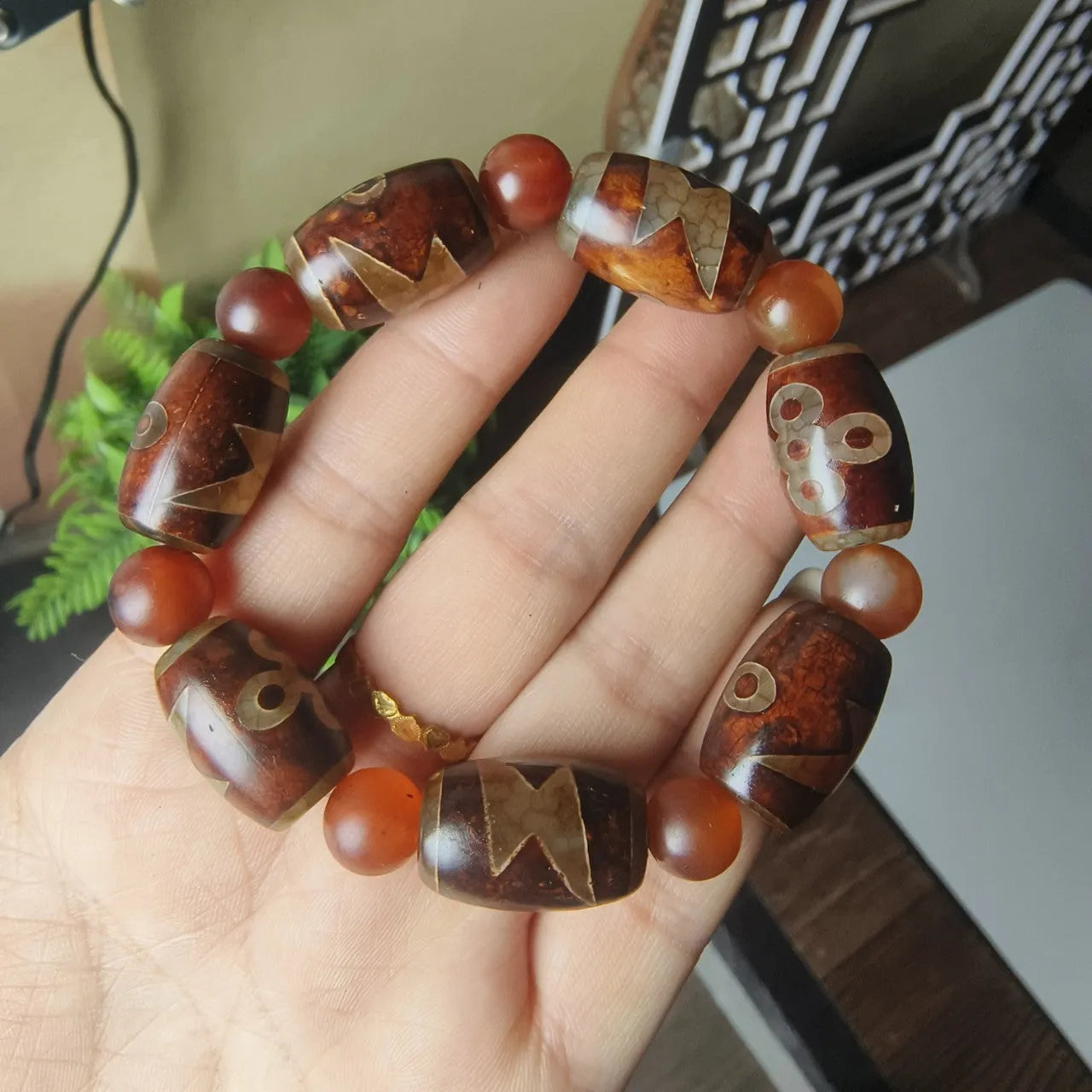 Distressed agate Tibet bead bracelet with three-eye motifs and multiple traditional bead styles on wrist